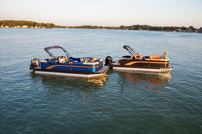 Two pontoon boats next to each other on the open waters at sunset.