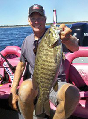 Kevin Short with a smallmouth bass caught on Lake Huron