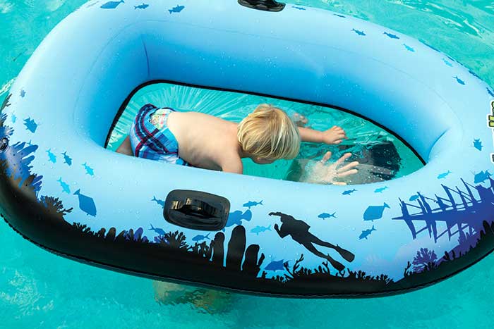 Young boy riding in the AquaVue Voyager snorkeling raft