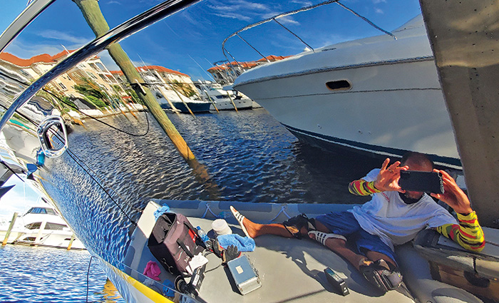 Reflection of a man taking a photo of his boat after waxing his vessel.
