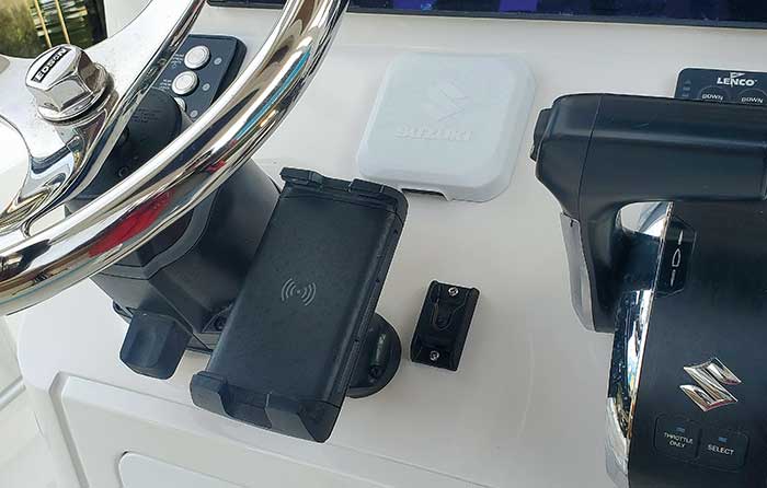 Dark gray-colored marine-rated wireless phone charger installed on boat helm