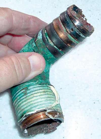 Close up view of a corroded small elbow pipe