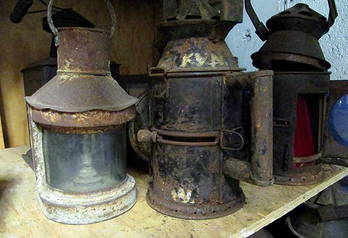 Old rusty boat lanterns sitting on an old wooden shelf