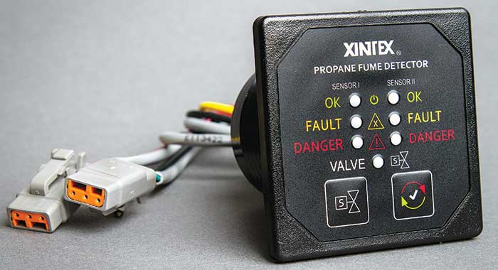 A product shot of a Xintex Propane Fume Detector - a black box with switches and cords attached