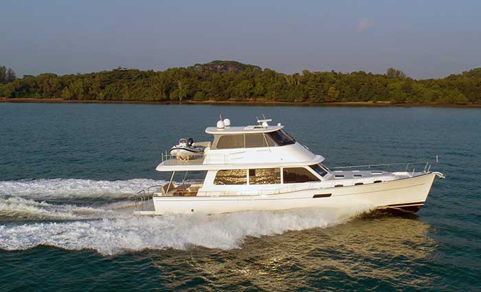 A large white powerboat - the Grand Banks 60 Skylounge - underway