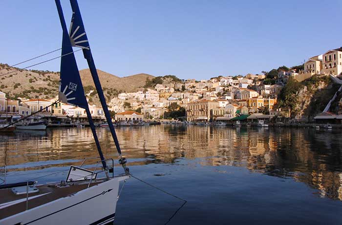 Morning in scenic Symi Harbor Greece with houses visible perched on a hill overlooking the harbor