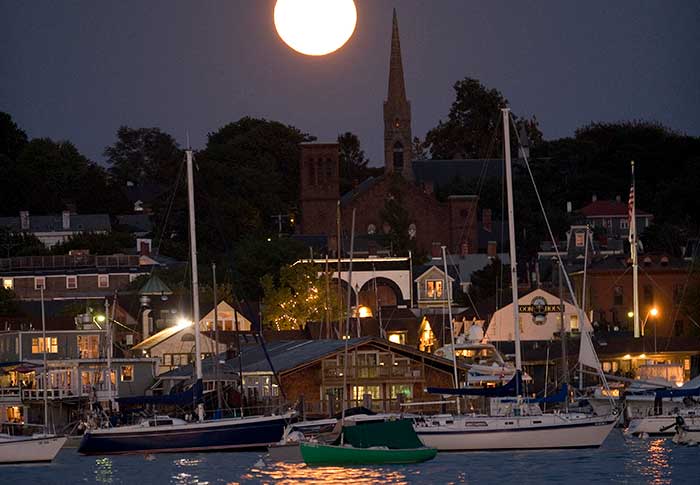 Boats at marina after dark with full moon overhead