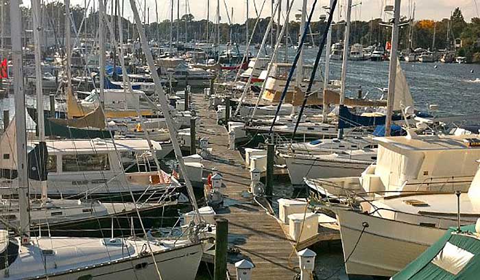 Many boats of different types and sizes docked at a crowded marina