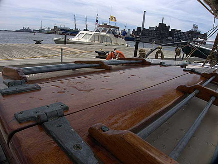 View from the bow of boat with dark wood finish along a dock