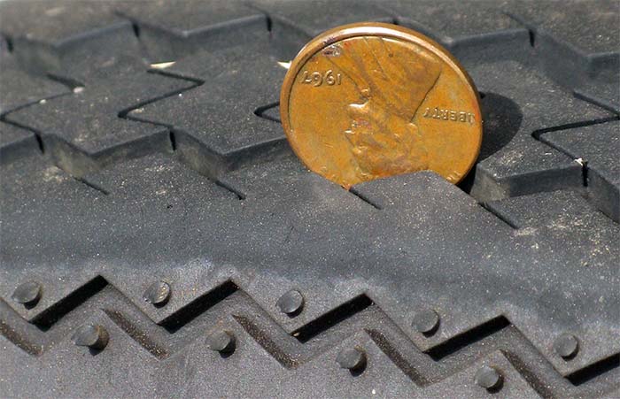 Copper penny stuck in tire to test the depth of the tire tread