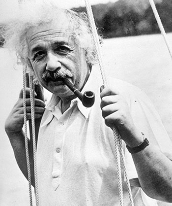 Black and white portrait of Albert Einstein smoking a pipe and hanging onto ropes from his sailboat while on the the water