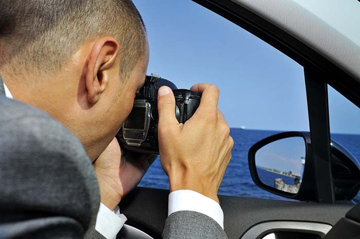 Close up of a man taking a picture to parts of a boat, as a procedure to investigate insurance fraud
