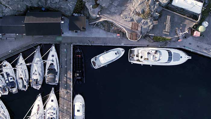 Aerial view of a smaller powerboat docking behind a larger powerboat