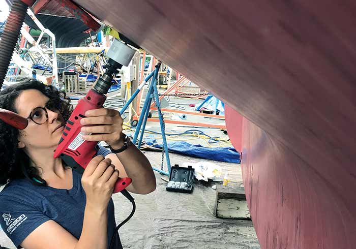 Sarah Scott drills a hole for a new thru-hull transducer