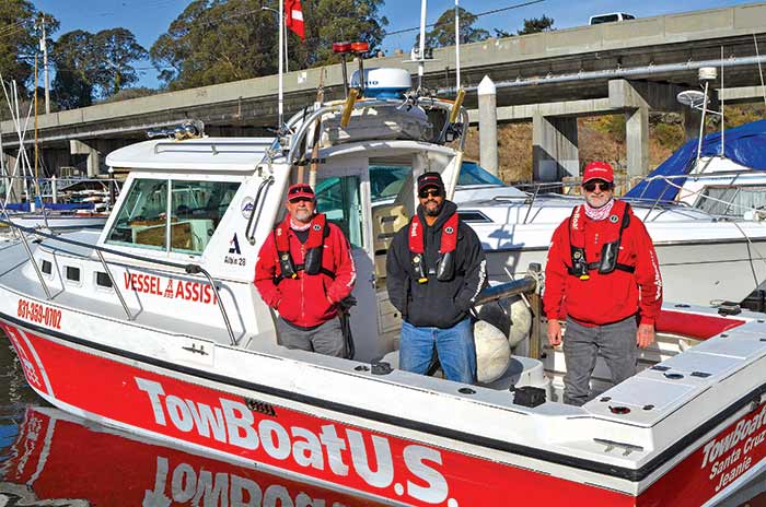 Three men standing aboard on a TowBoatUS Santa Cruz vessel