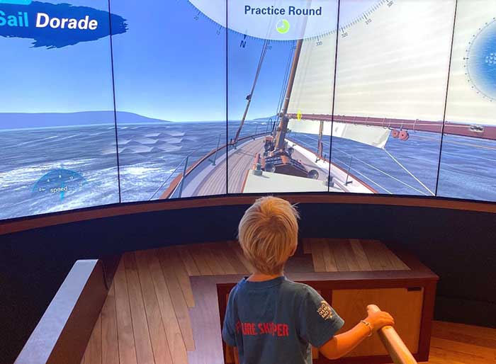 Young boy using an interactive sailing exhibit at the Sailing Museum