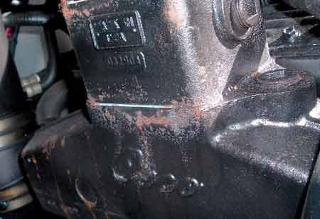 a close up look of a black with rust coloring stern drive gasoline engine