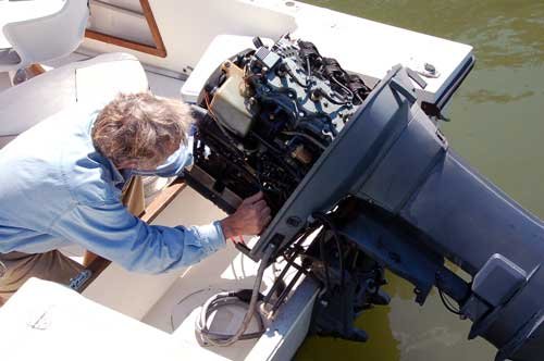 Checking "under the hood" of his outboard