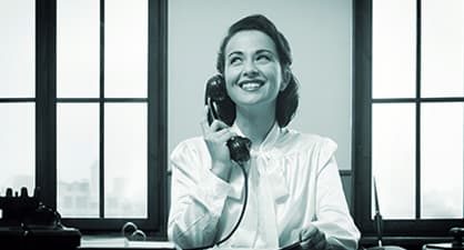 black and white of a woman smiling while on the phone