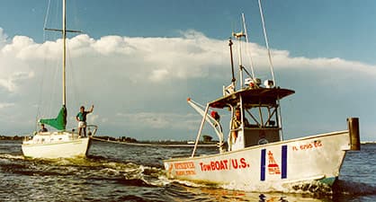 A boatus affiliated towboat towing a yacht to shore